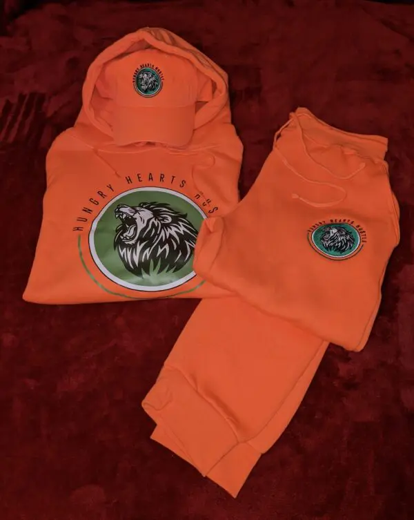 A pair of orange sweatpants and hoodie with an animal on it.