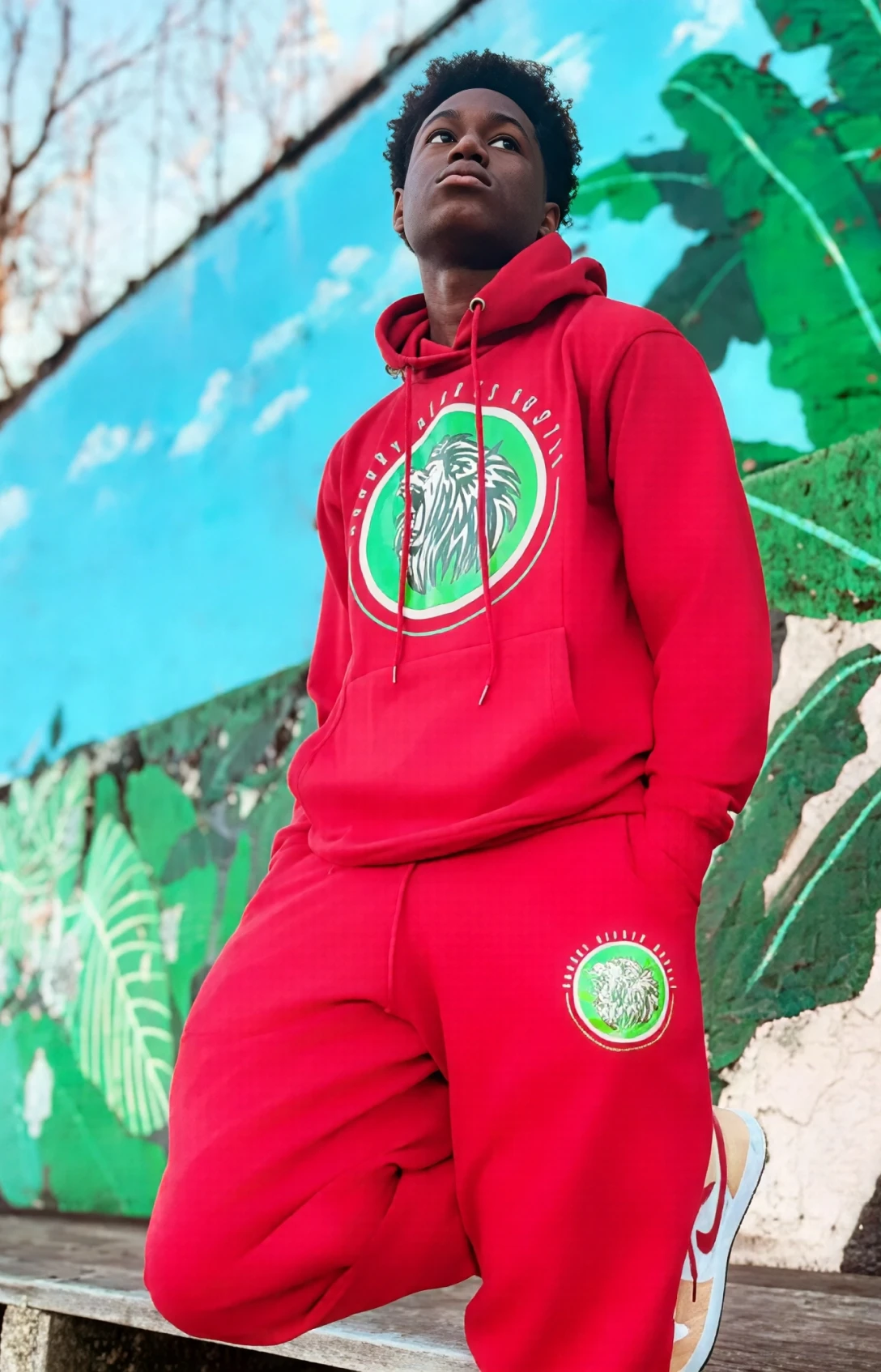 Person in red tracksuit near mural