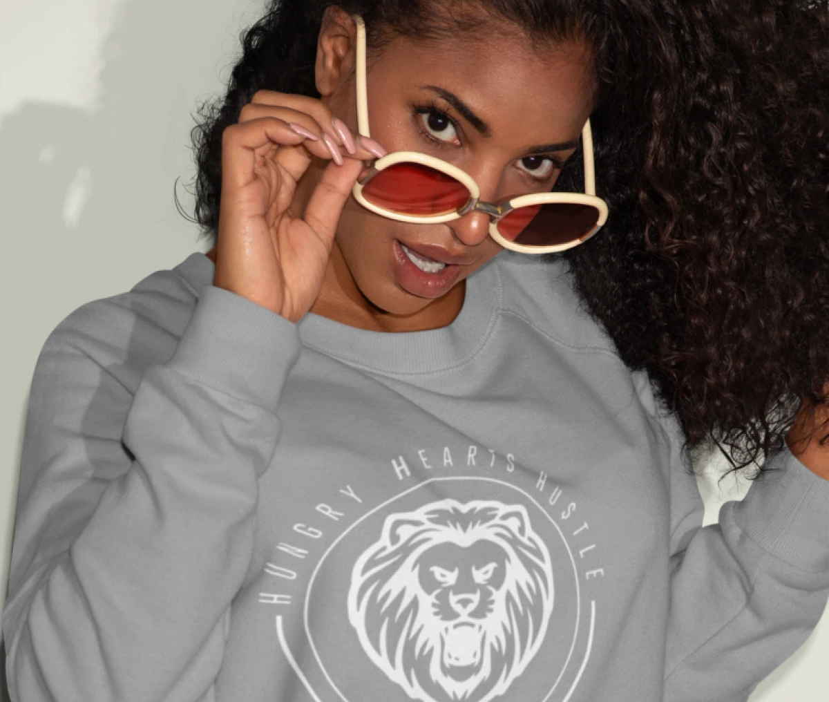Woman wearing sunglasses and lion sweatshirt