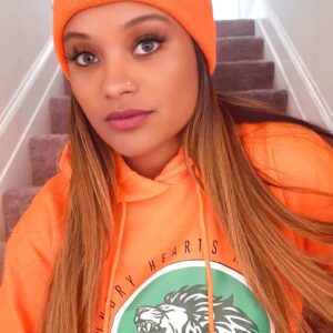Woman in orange hoodie with lion logo